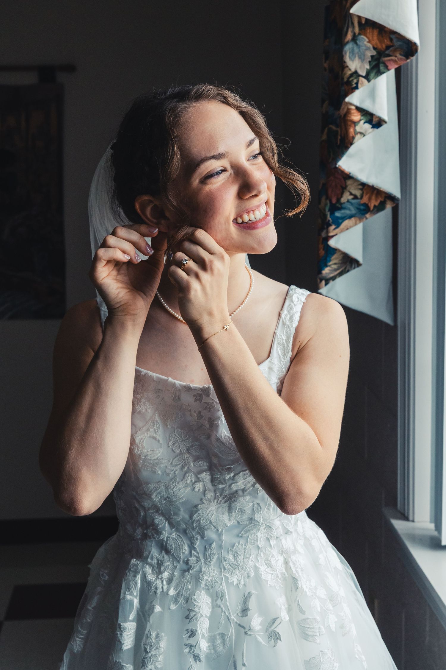 Bride putting on earrings during wedding getting ready in Palm Beach Gardens