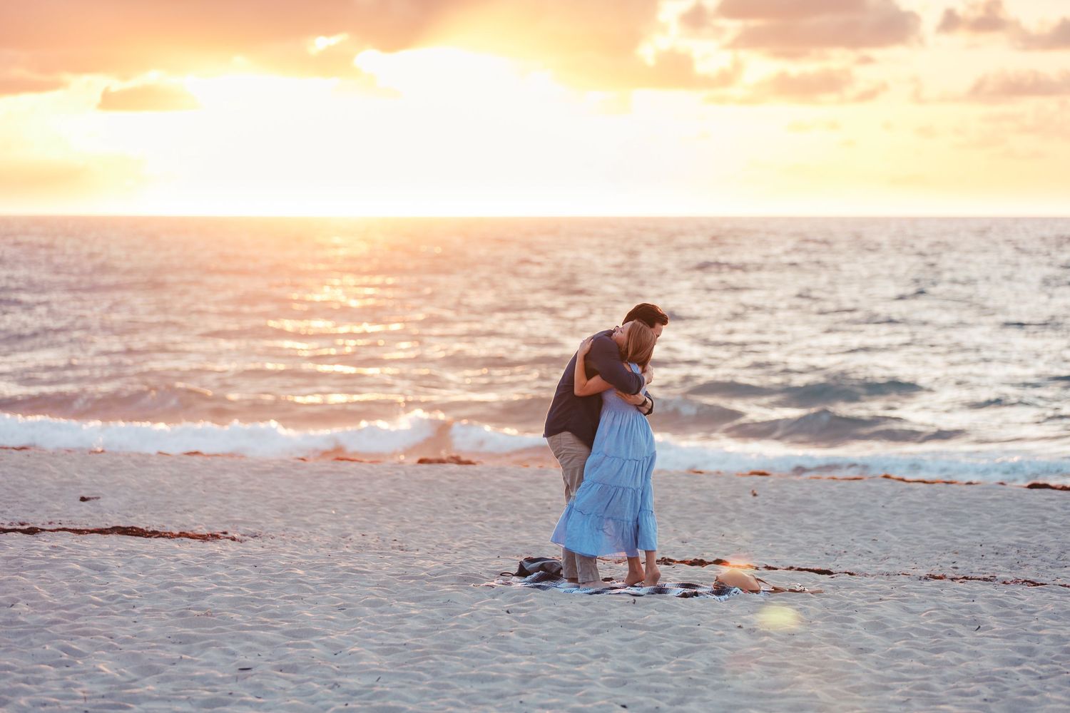 Couple embracing on the beach at sunset during West Palm Beach Florida engagement session