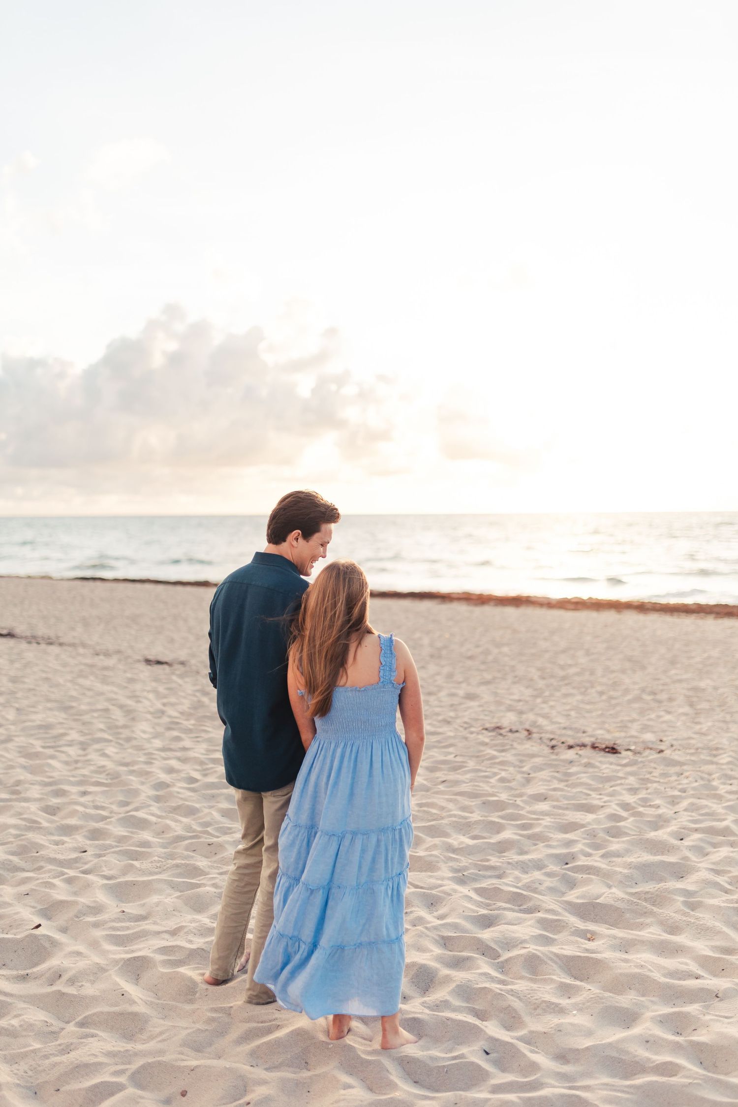 Couple walking on the beach at sunset during Palm Beach Gardens engagement session