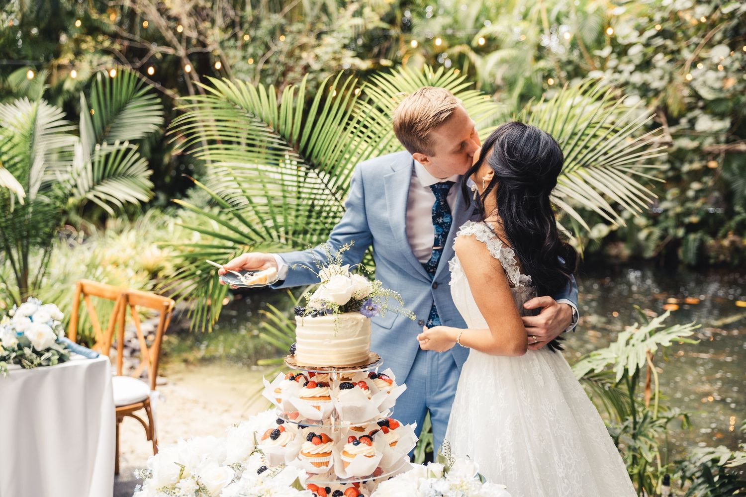 Bride and groom cutting cake during garden wedding reception in Palm Beach Gardens