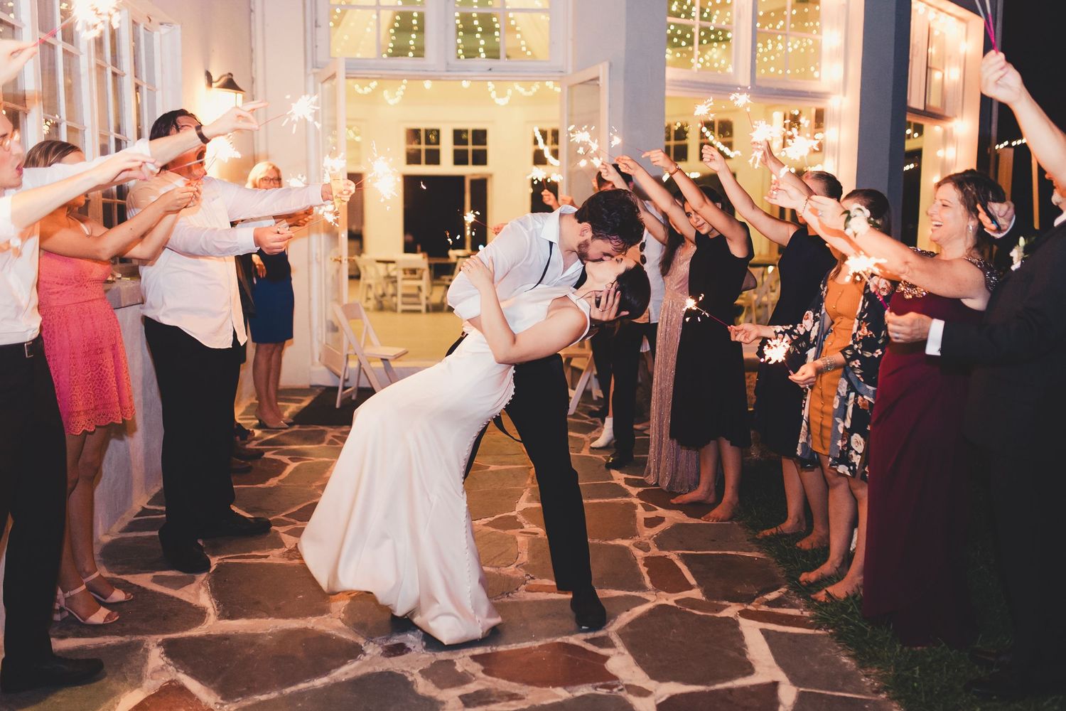 Bride and groom kissing during wedding exit celebration in Palm Beach Gardens