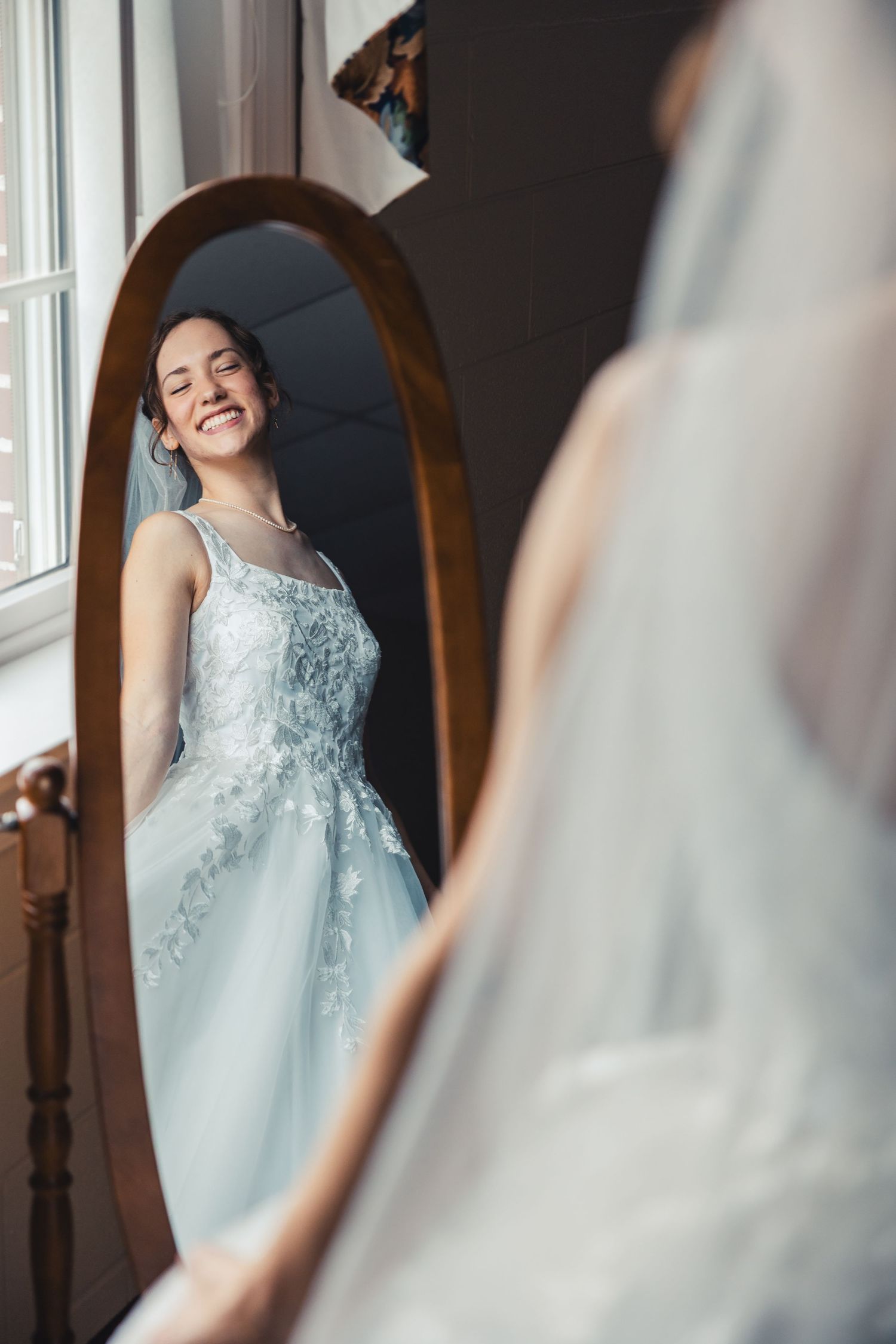 Bride smiling in mirror during wedding getting ready in West Palm Beach Florida