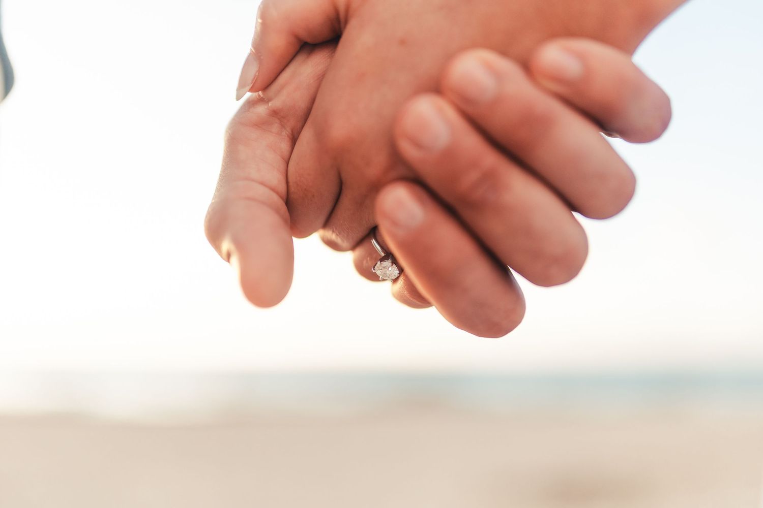 Couple holding hands during beach engagement session in Palm Beach