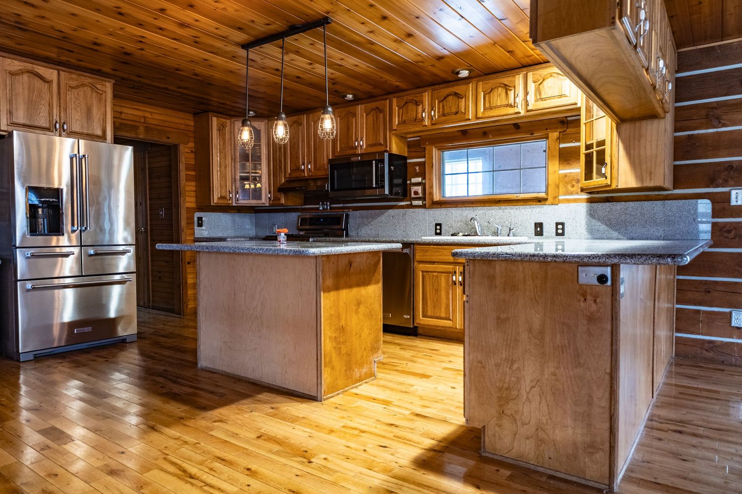 Modern rustic kitchen and living area with wood cabinets and hardwood flooring.