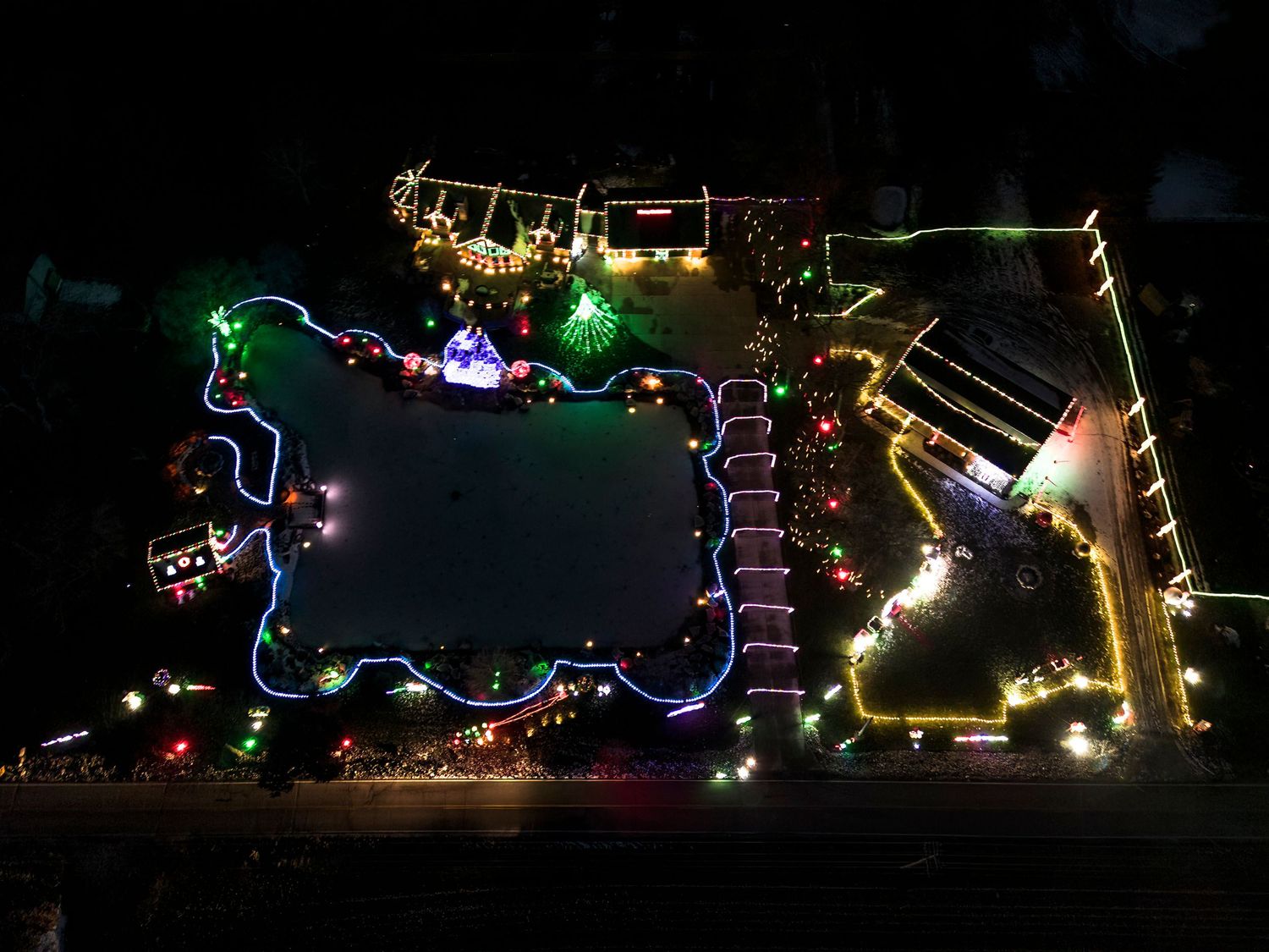 Holiday light display featuring colorful LED outlines and decorative patterns in the darkness.
