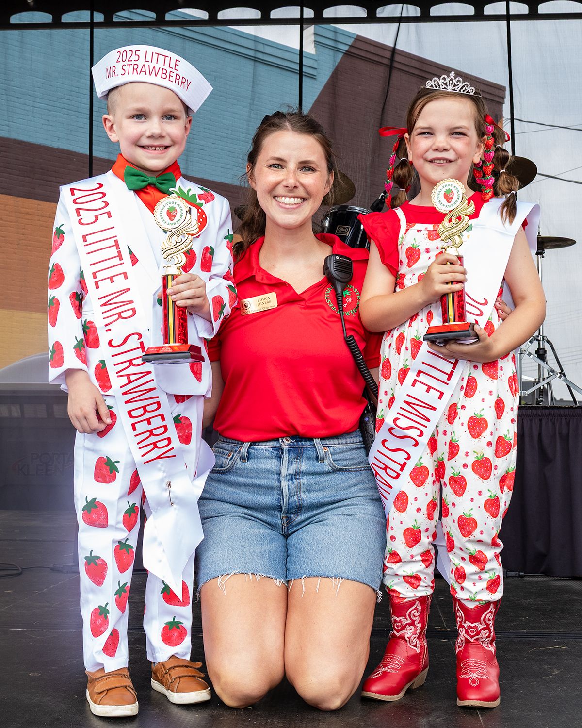 Group photo of festival participants wearing strawberry-themed outfits and sashes.