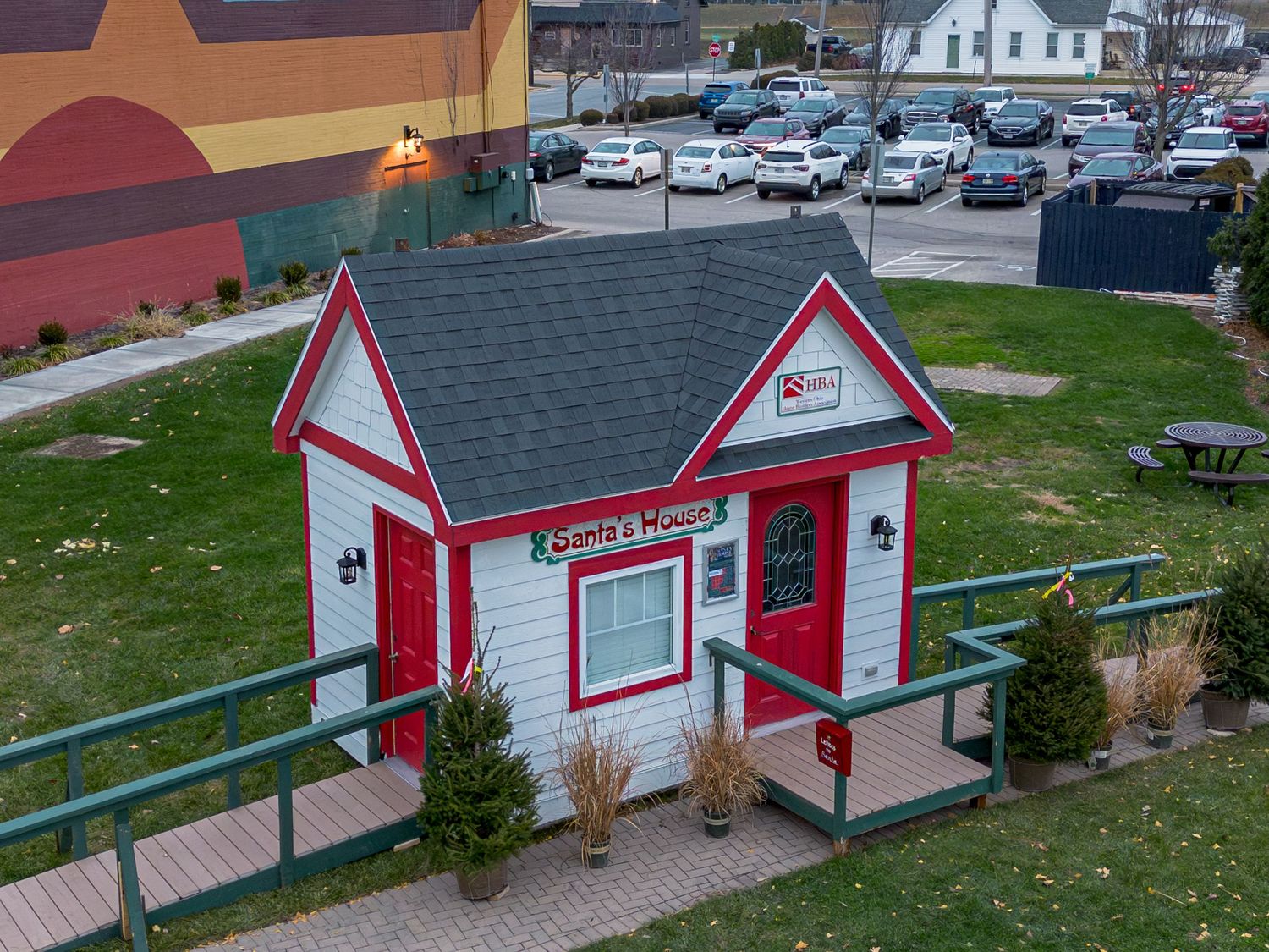 Row of small red and white buildings with pitched roofs and holiday decorations.