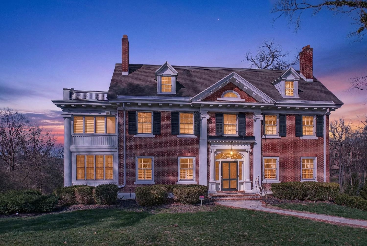 A series of luxury homes photographed at dusk with warm glowing windows and dramatic twilight skies.