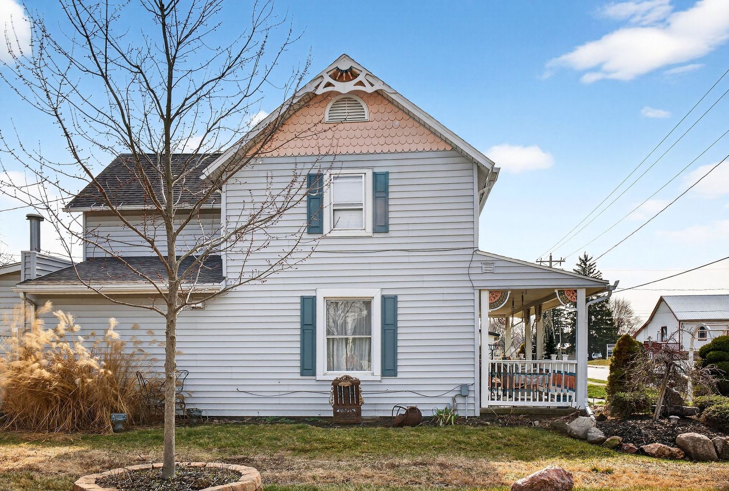 A white farmhouse exterior with multiple angles showing the siding, windows, and architectural details in rural setting.