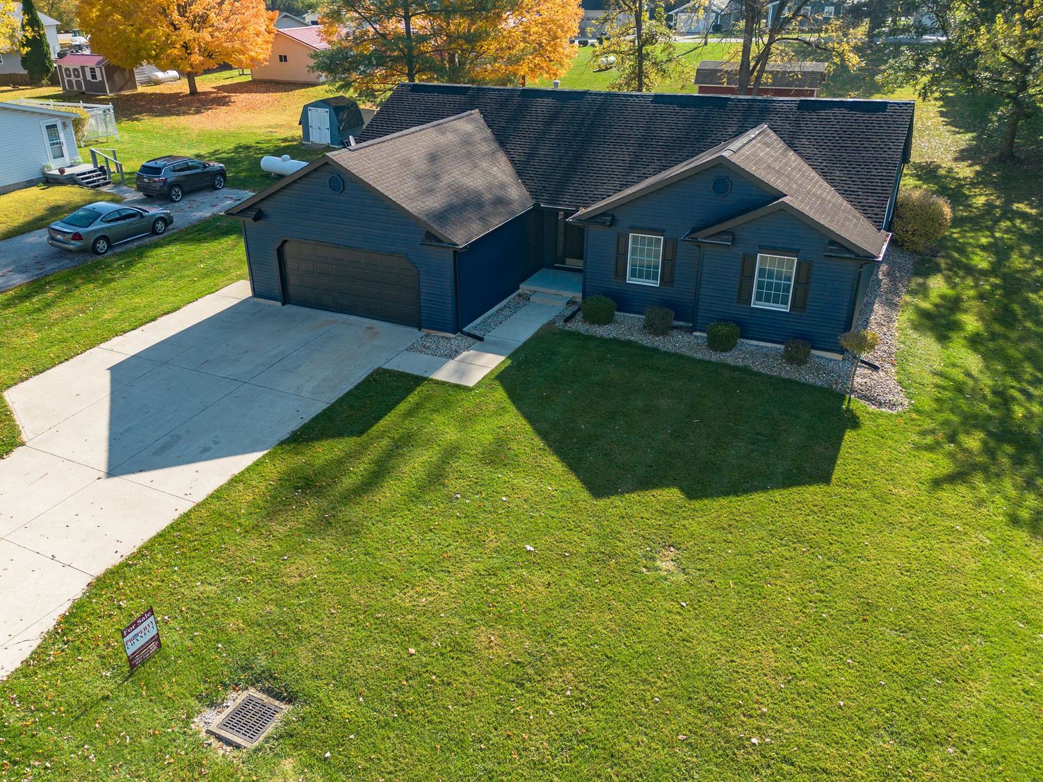 Aerial view of a modern suburban home with well-maintained lawn and driveway.