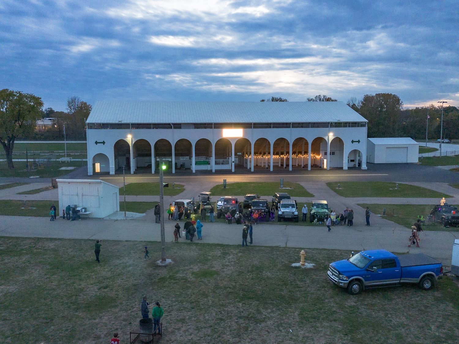 Panoramic daytime view of an airport terminal with small planes and vehicles visible.