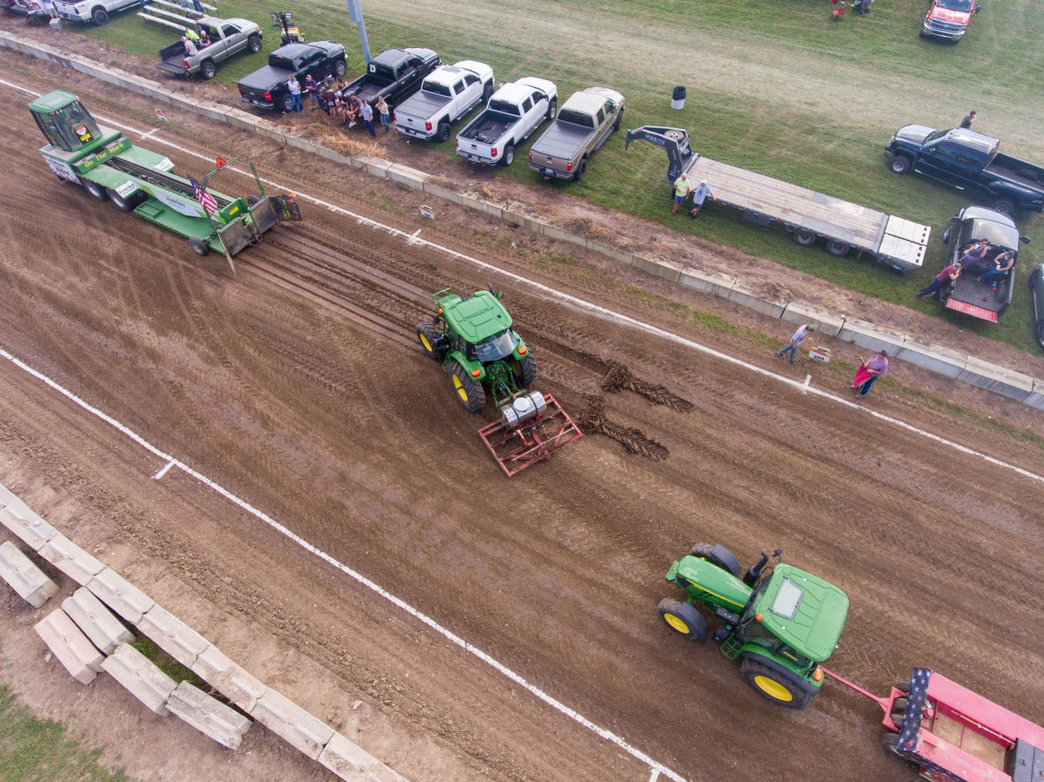 Aerial view of vehicles and equipment on dirt track or construction site.