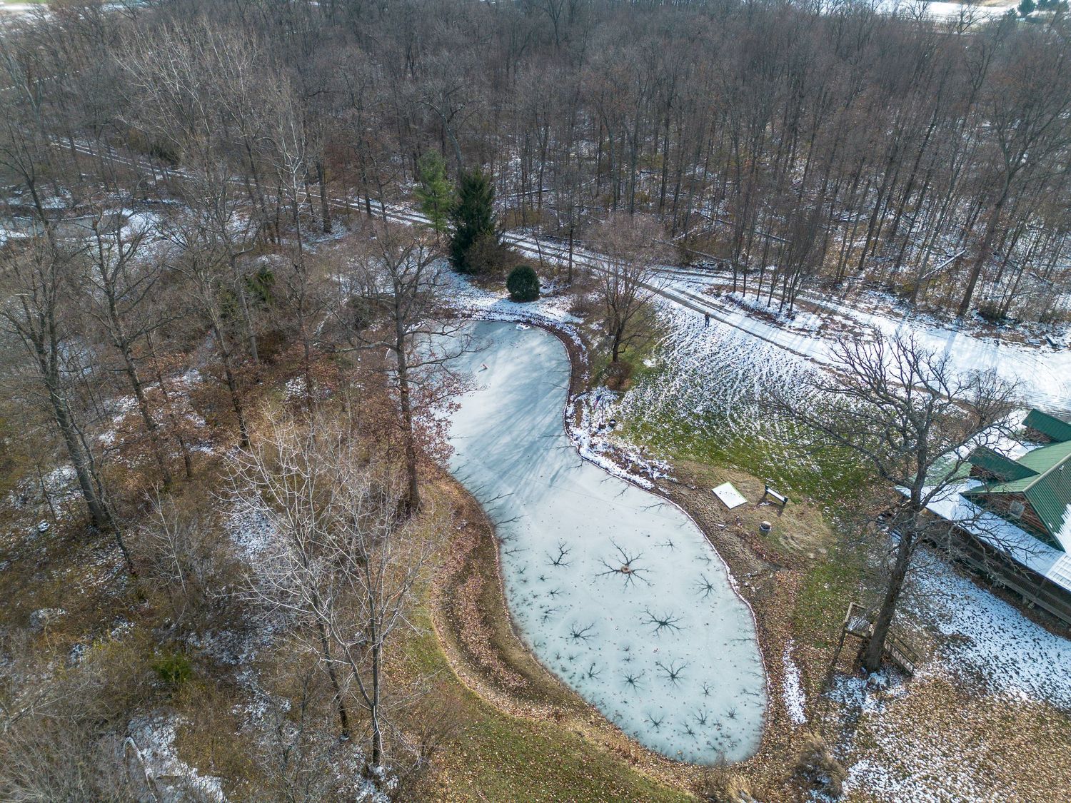 Aerial panoramic view of a snow-covered lodge property surrounded by winter forest landscape.