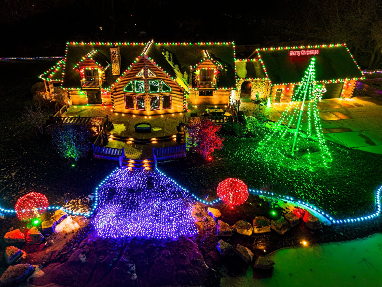 Vibrant Christmas light display with multicolored LED arrangements and festive yard decorations.