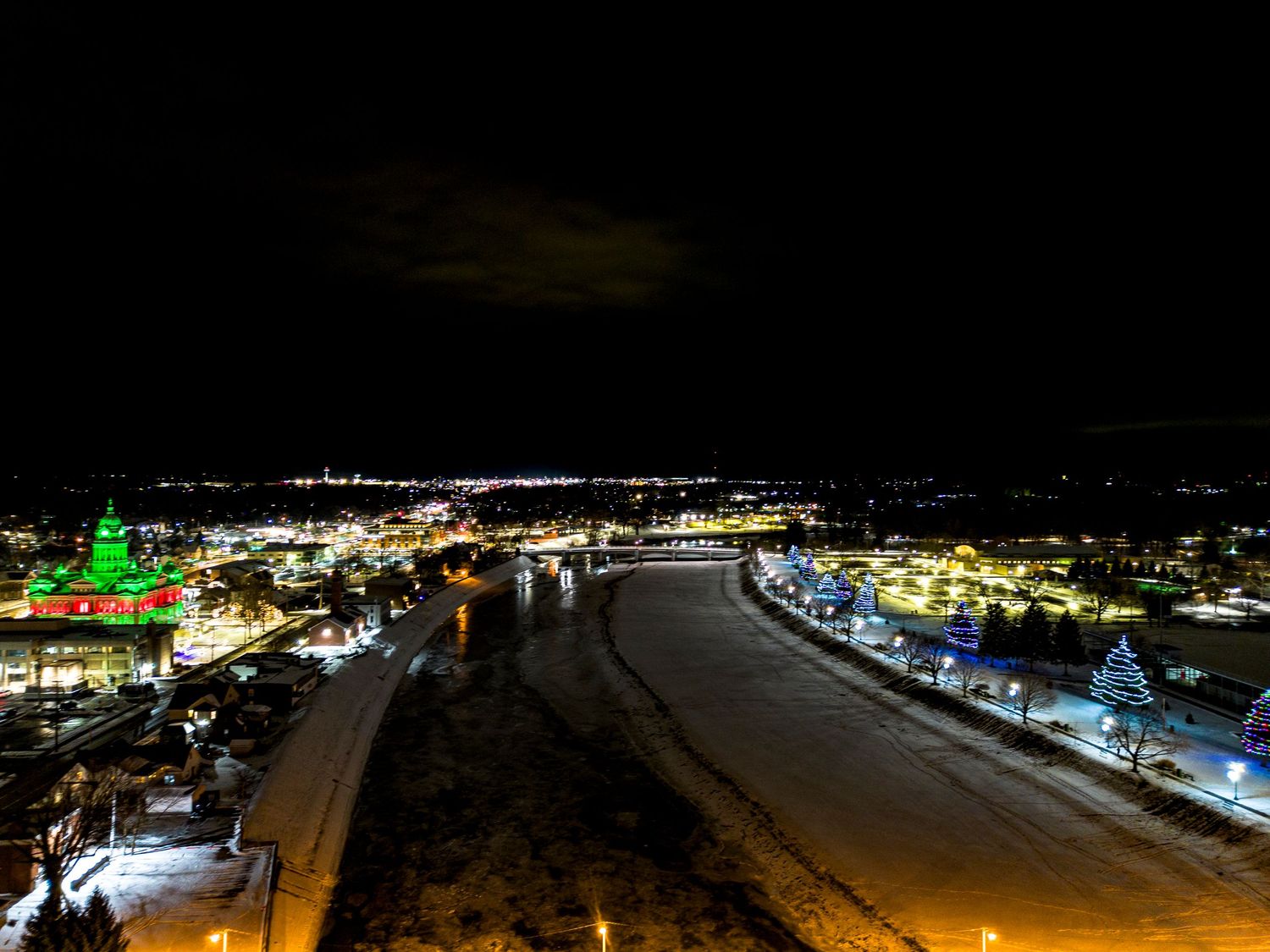 Panoramic nighttime view of city lights and illuminated buildings stretching across the horizon.
