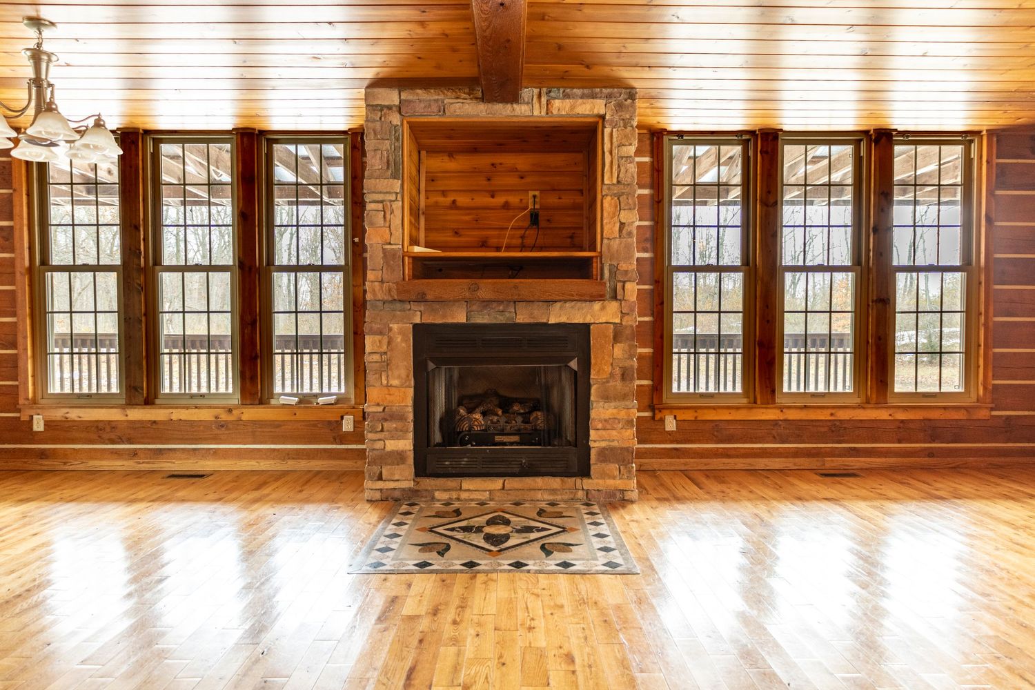 Large open concept lodge interior with wood walls, floors and abundant natural light.