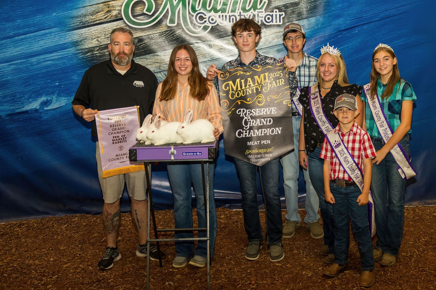 Group photo of award winners with certificates at county fair.