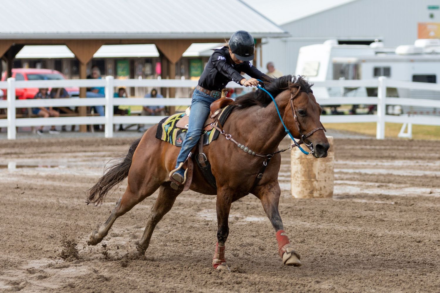Multiple riders competing in barrel racing event at rodeo arena.