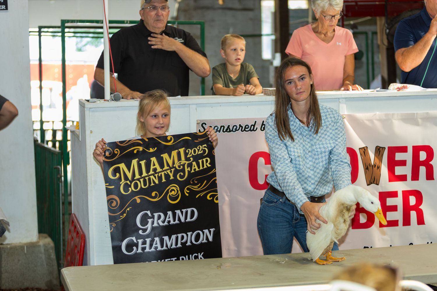 Award ceremony display with signs and banners at county fair event.