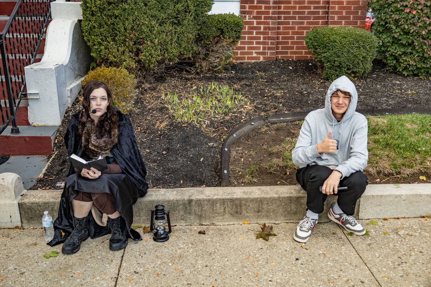 Group of people sitting on brick steps outside a building during a casual gathering.