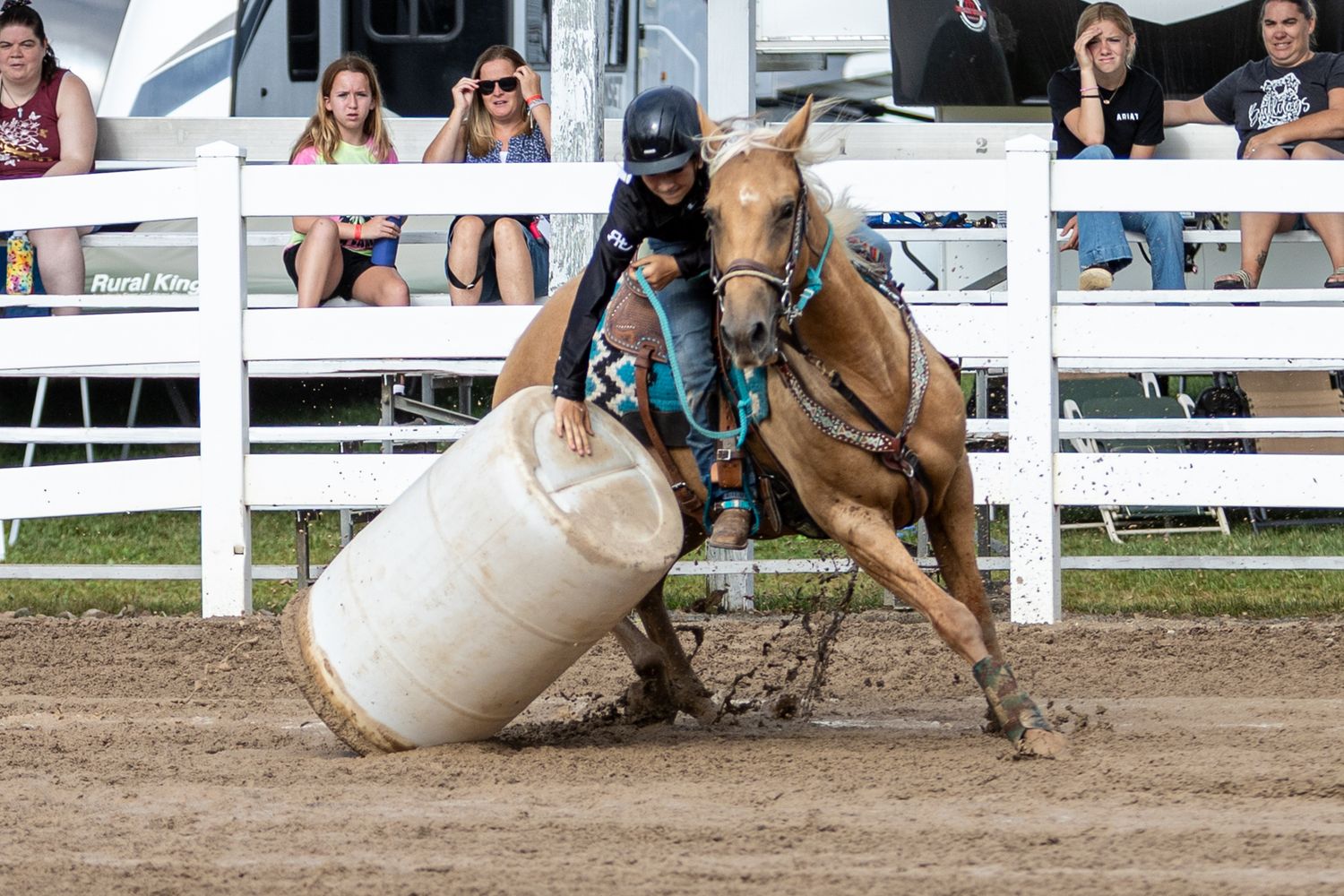 Action sequence of rodeo steer wrestling competition in dirt arena.