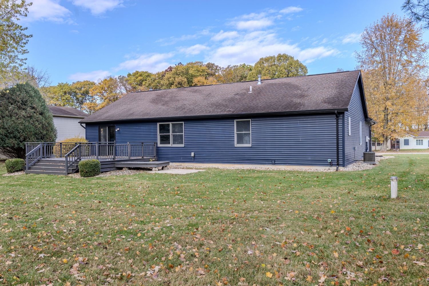 Wide angle view of suburban homes with manicured lawns during fall season.