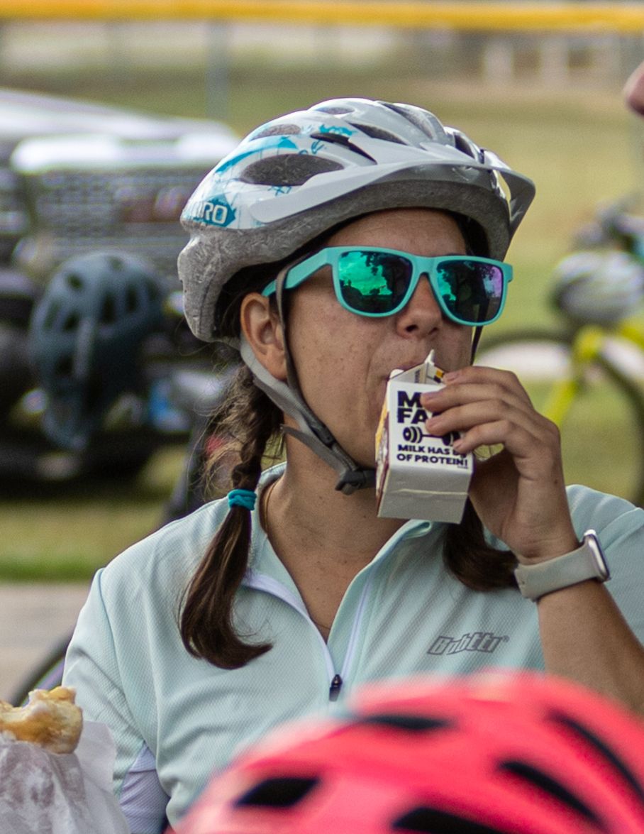 Cyclists taking drinks during a break at an outdoor biking event.