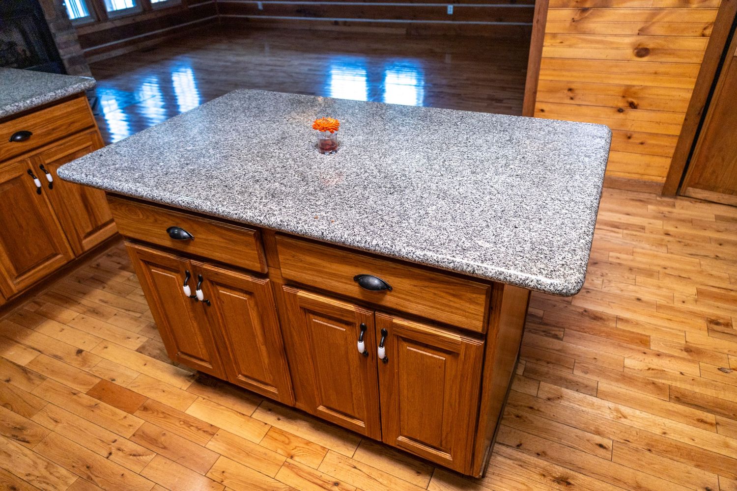 Kitchen countertops and cabinets in rustic wooden lodge interior.