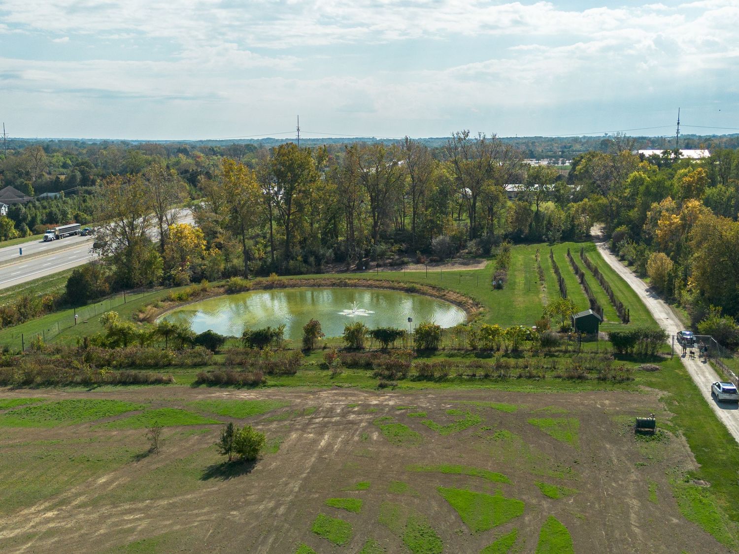 Panoramic aerial view of farmland and rural landscape with scattered buildings and roads.