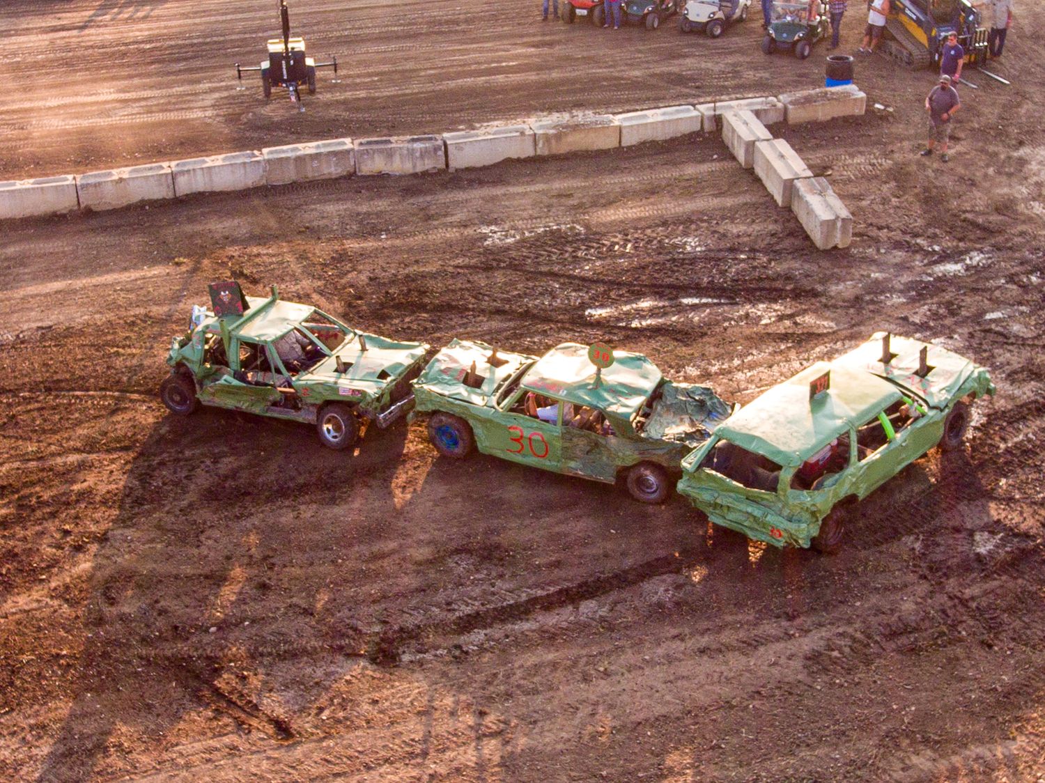 Aerial view of demolished building debris and rubble on brown dirt surface.