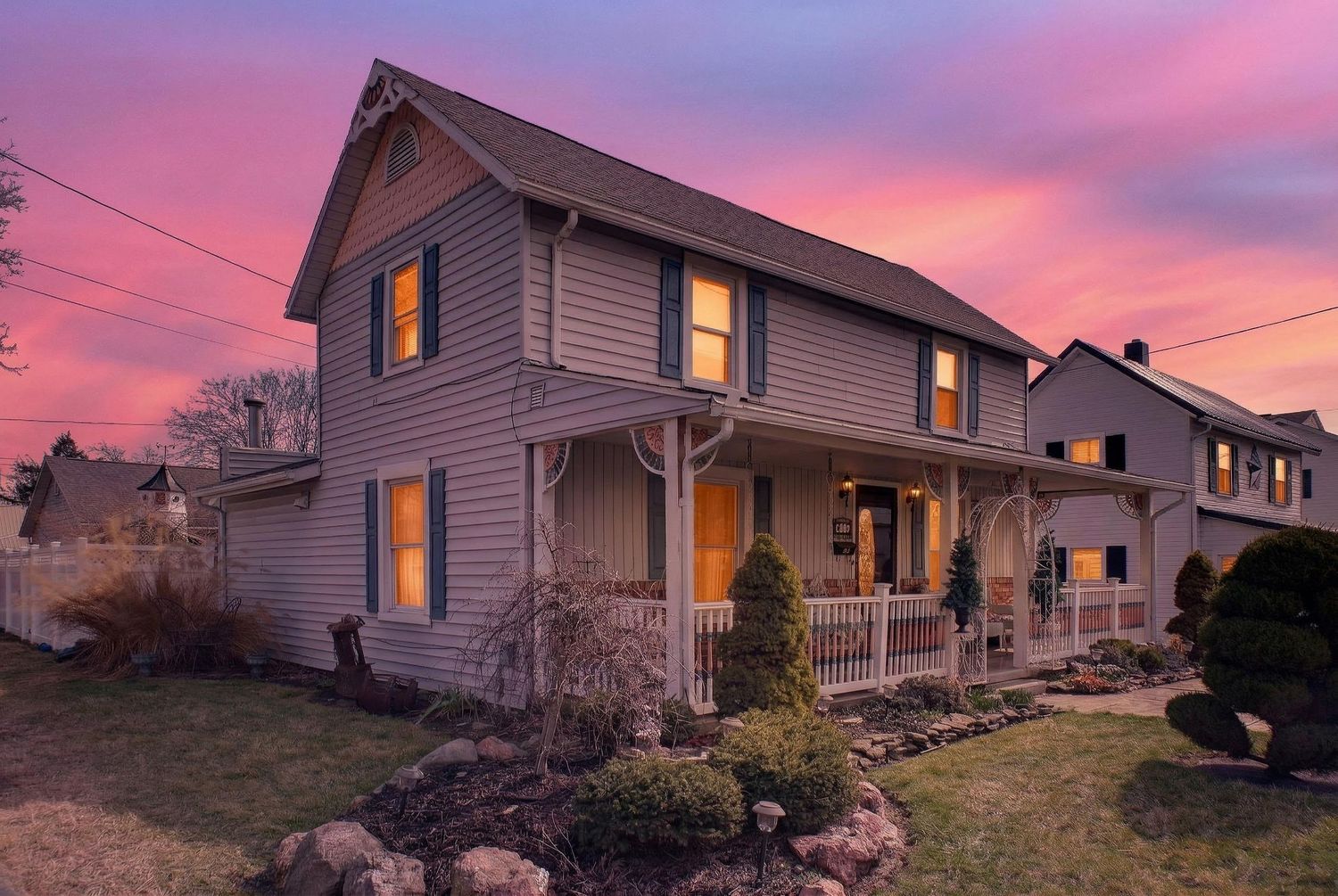 A series of residential houses with illuminated windows at sunset creating a warm and cozy atmosphere.
