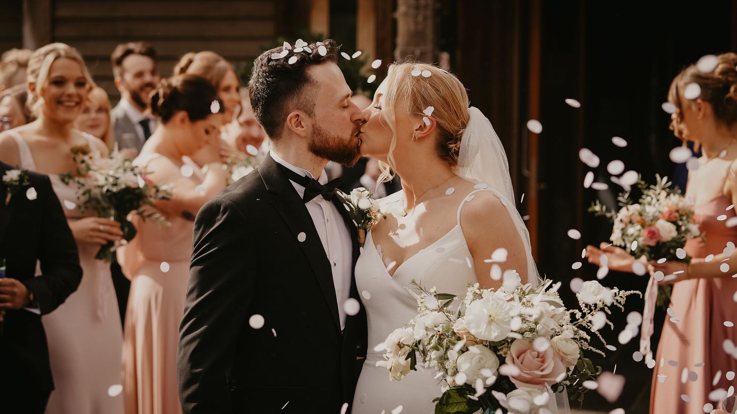Wedding celebration with confetti and floral decorations in warm lighting.