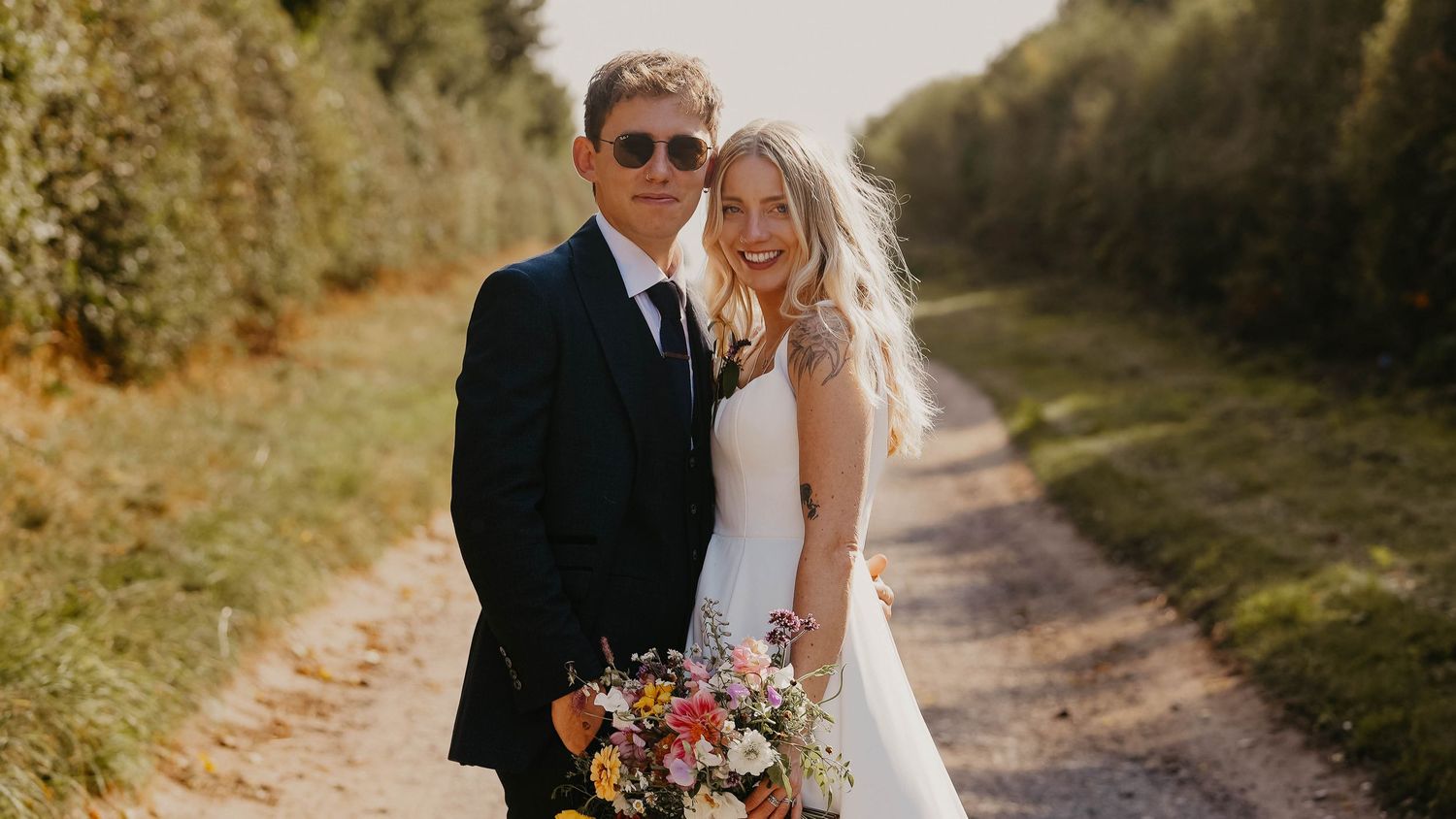 Romantic outdoor wedding photography session on a rustic dirt path.