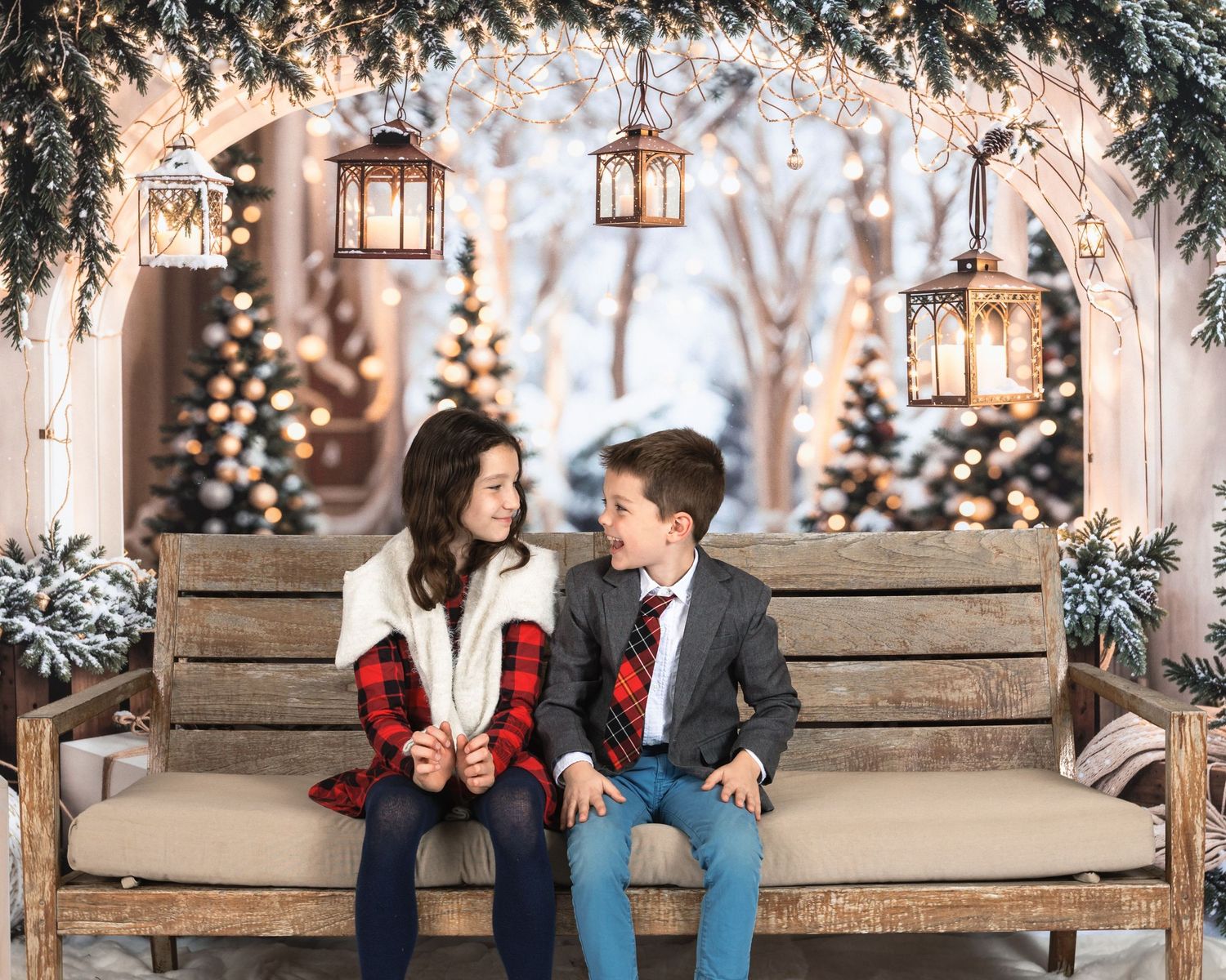 A romantic winter engagement photo session with a couple sitting on a bench surrounded by twinkling lights and lanterns.