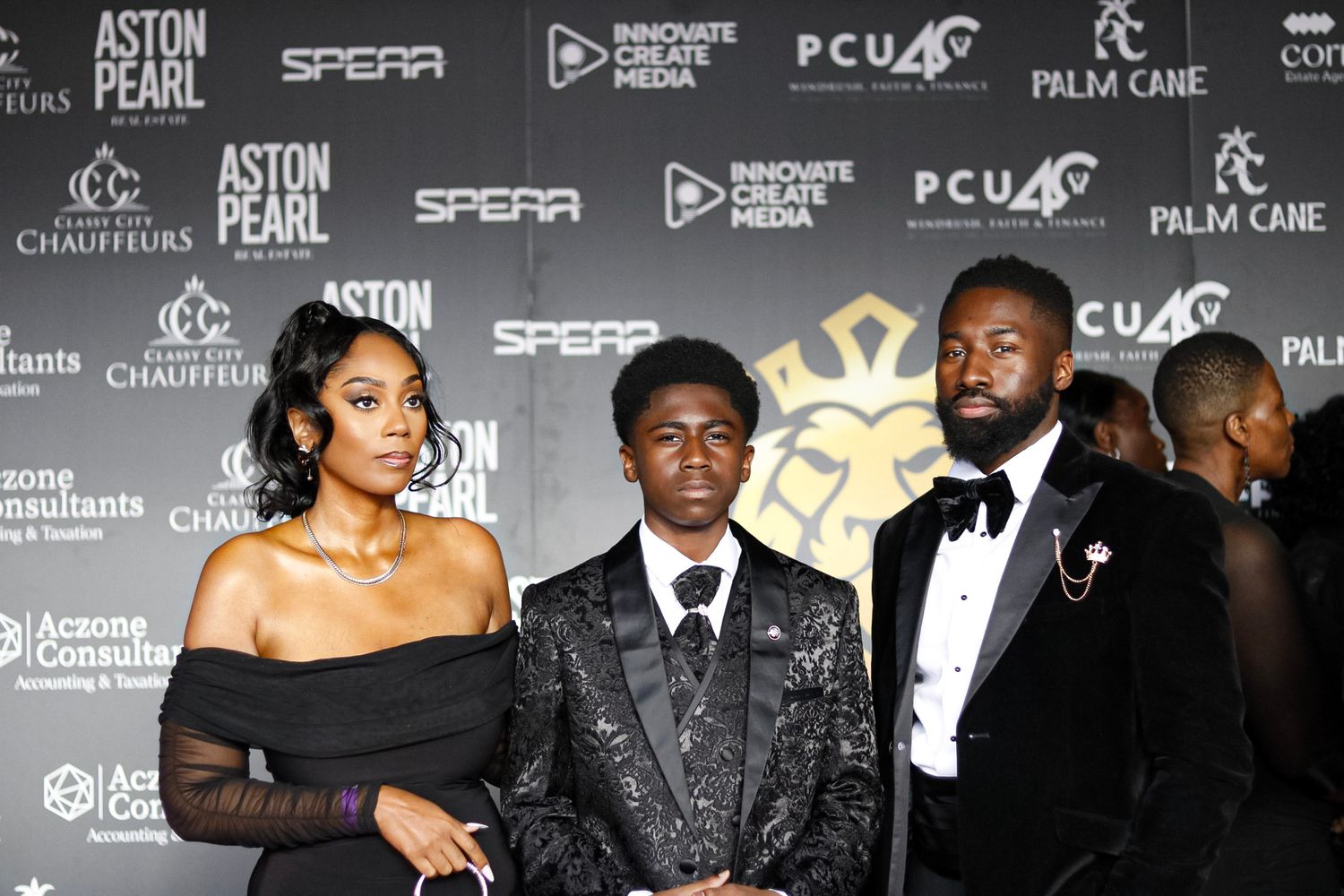 Red carpet event with branded backdrop showing attendees in formal attire.