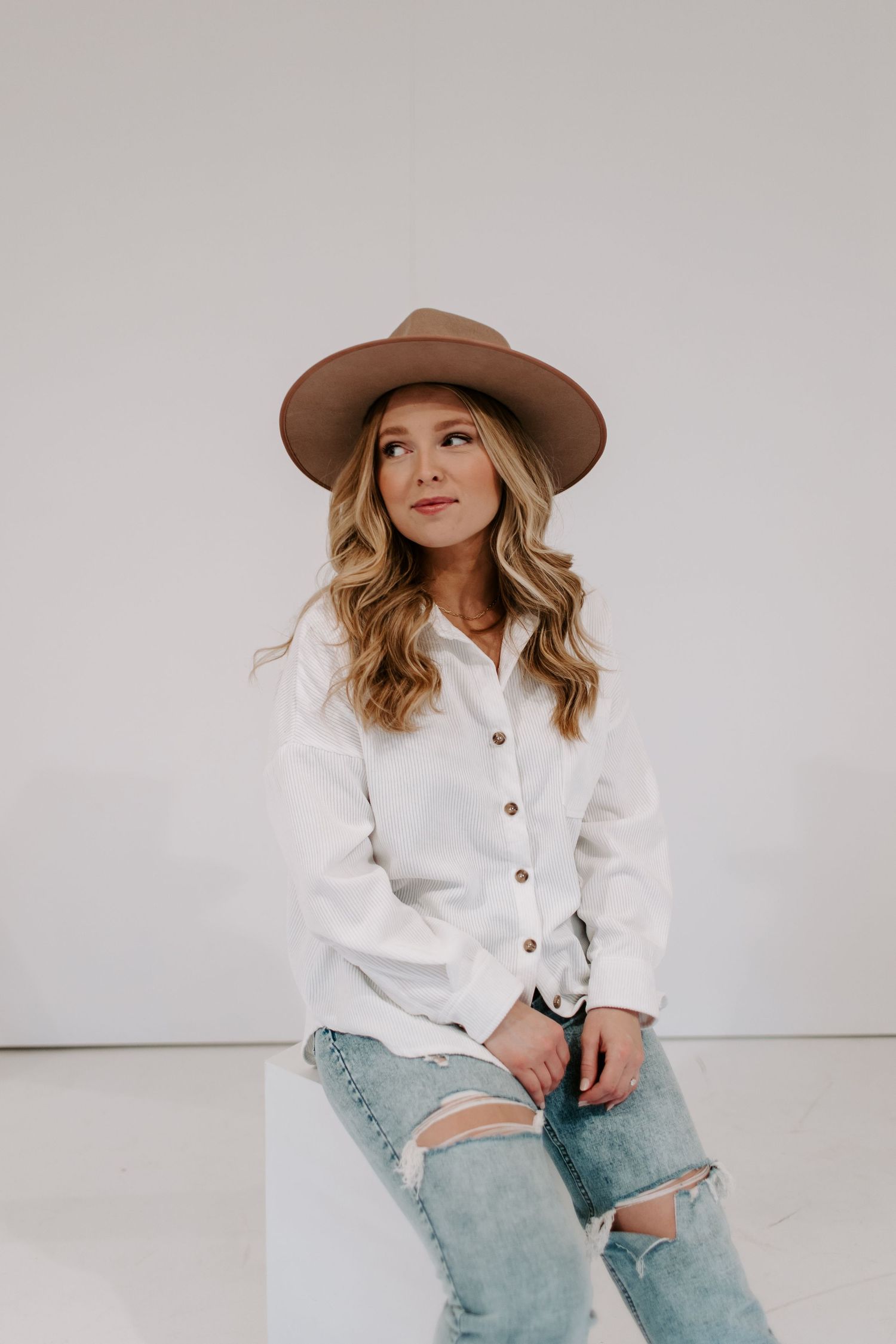 photographer poses for studio photo with white background