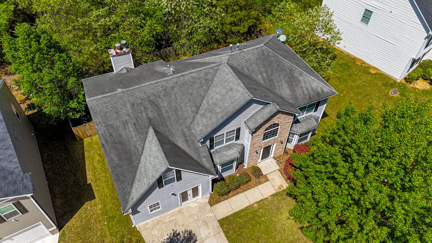 Aerial view of residential properties surrounded by lush green landscaping and trees.