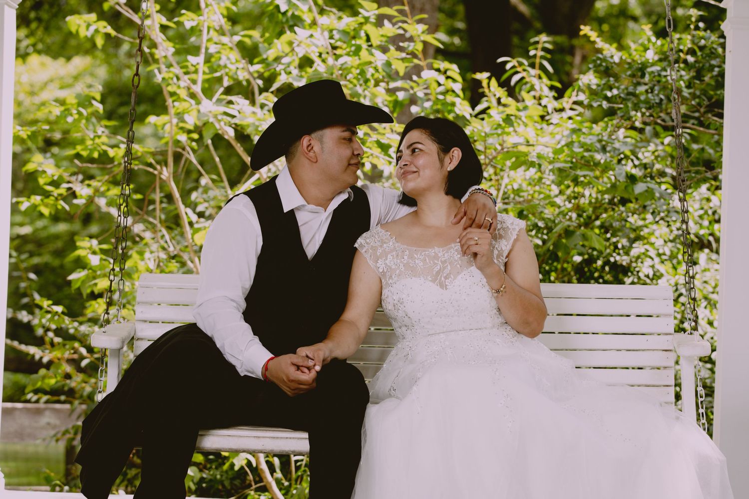 A romantic scene captured on a Southern style porch with lush green foliage.