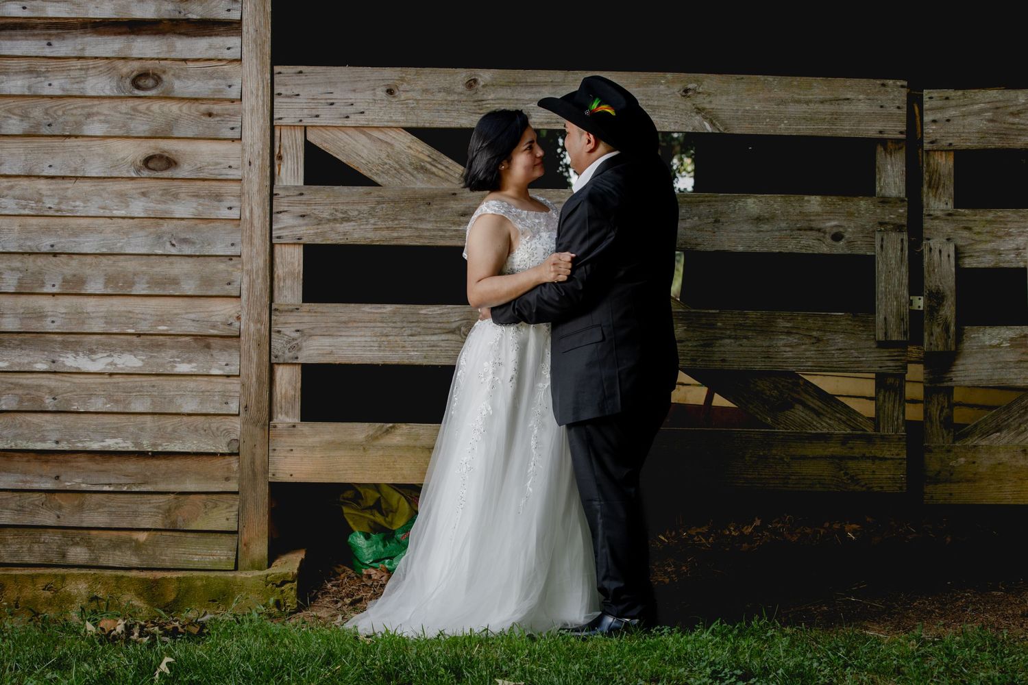 A romantic moment captured in a rustic barn setting with a flowing white wedding dress.