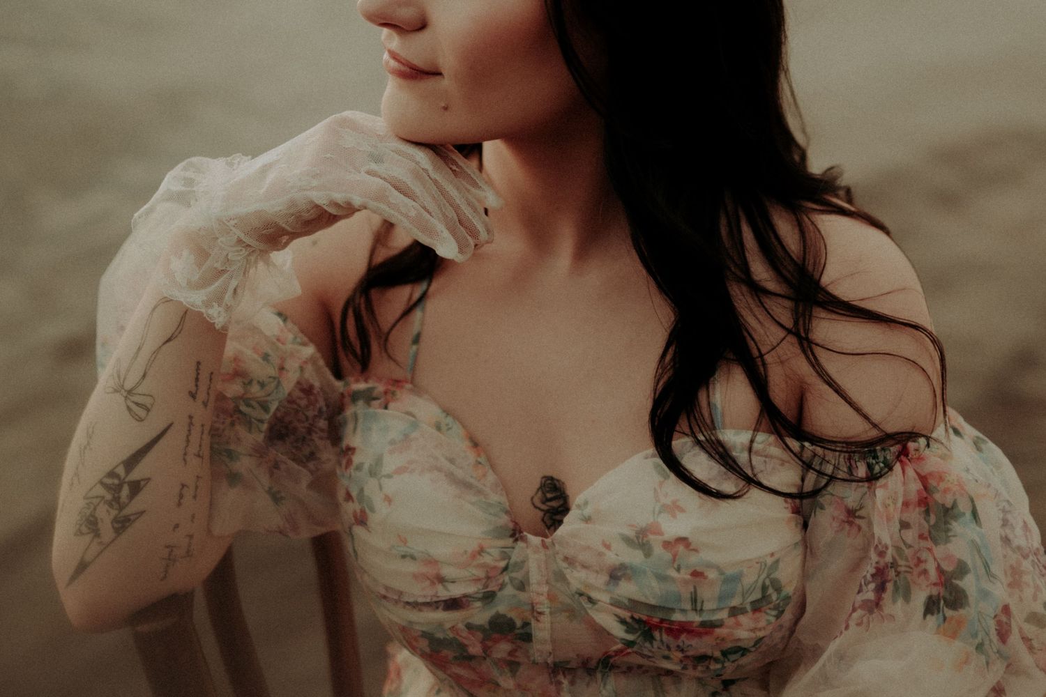 Close-up shot of delicate off-shoulder floral dress details in warm muted tones.