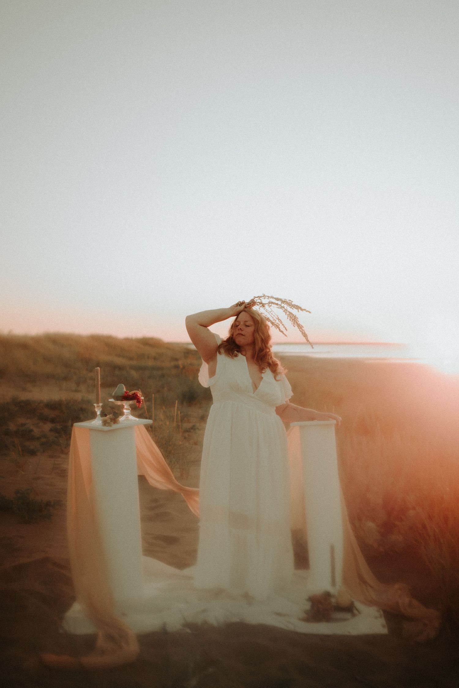 Ethereal series of white dresses flowing in golden sunlight against a desert landscape at sunset.