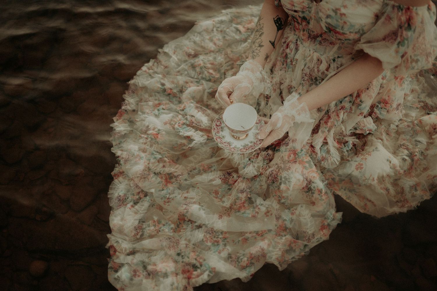 Dark and moody underwater fashion photography with floating fabric details.