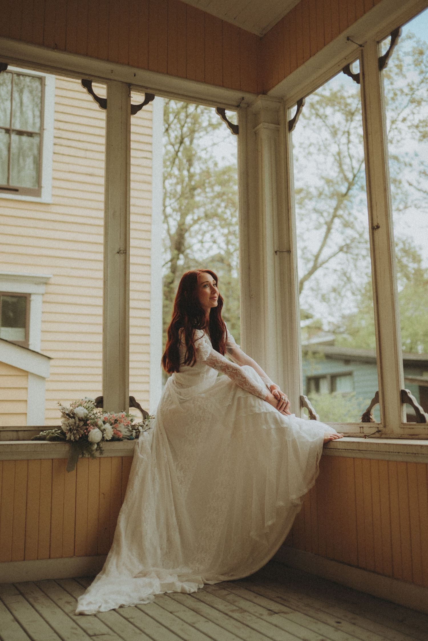 A romantic bridal photo showing a flowing white dress against the backdrop of a vintage porch.