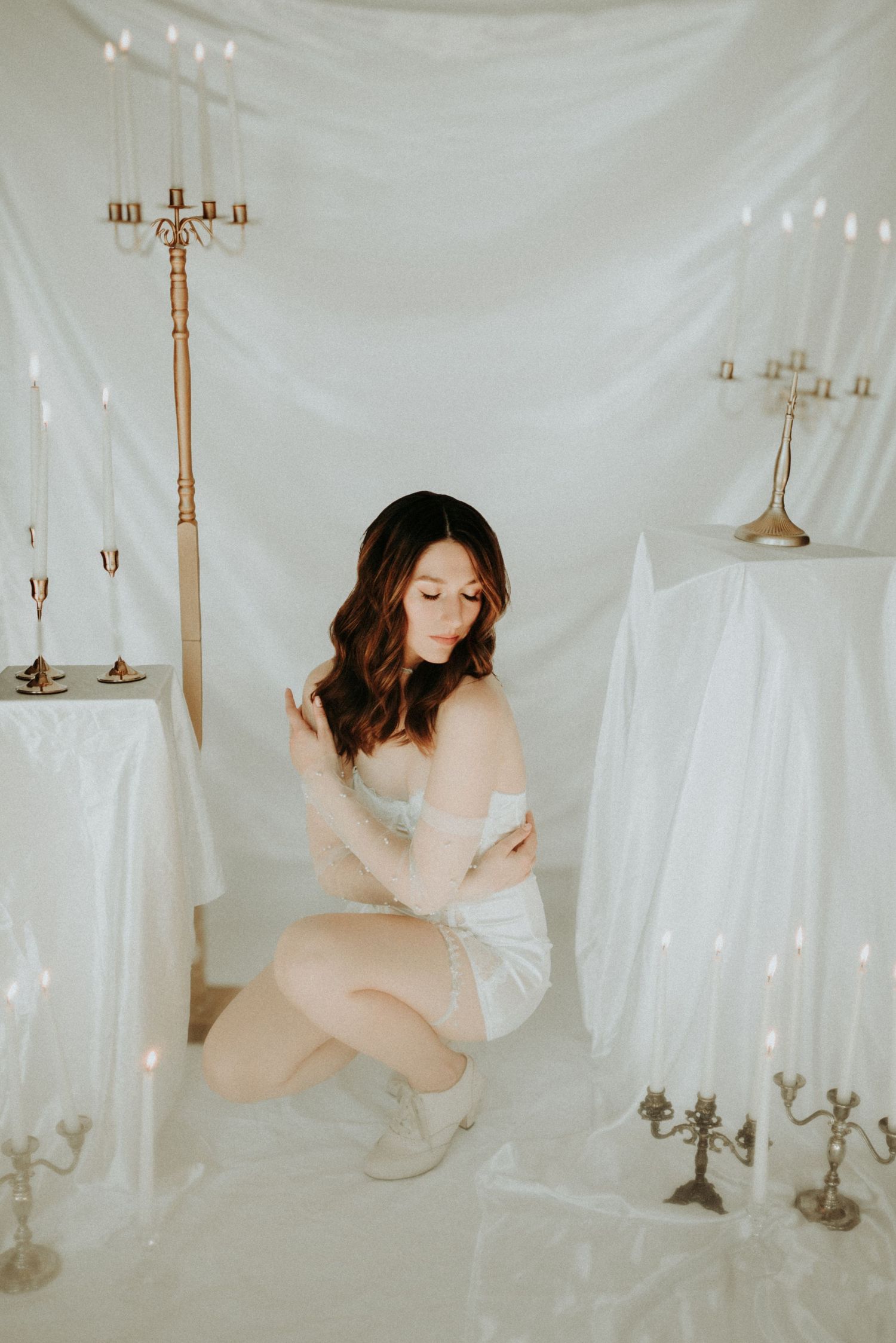 Ethereal artistic photo series featuring draped white fabric and vintage candelabras creating a dreamy atmosphere.