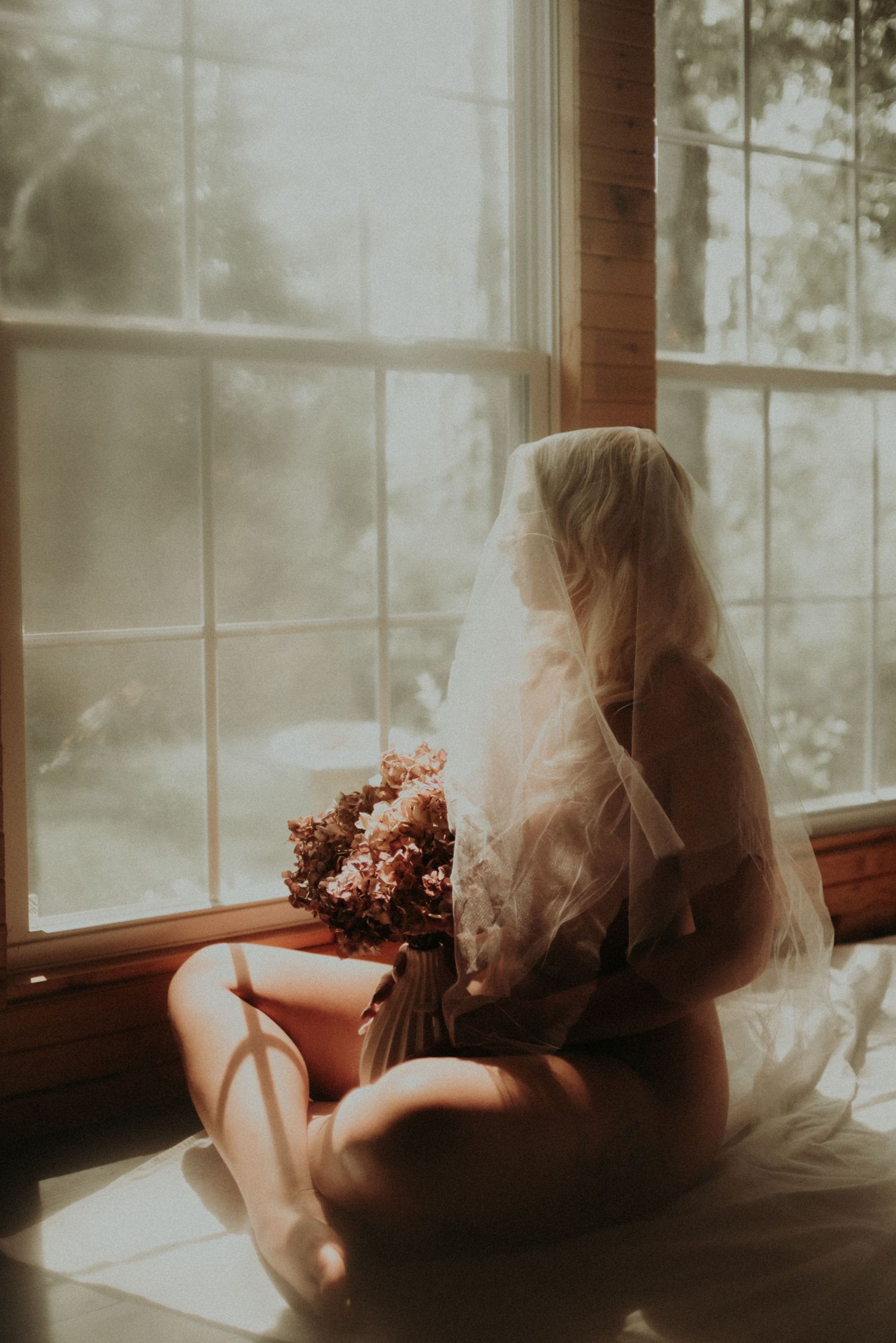 Artistic boudoir sequence showing silhouette against bright window with floral elements.