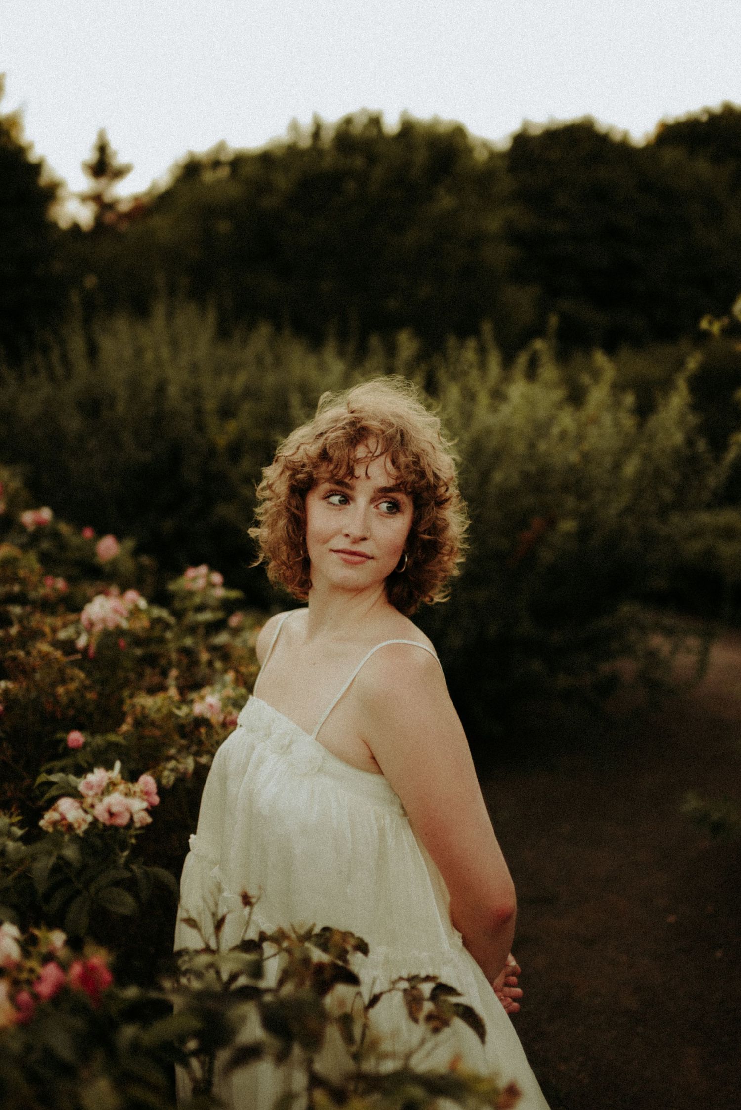 Romantic garden portrait among blooming flowers at sunset.