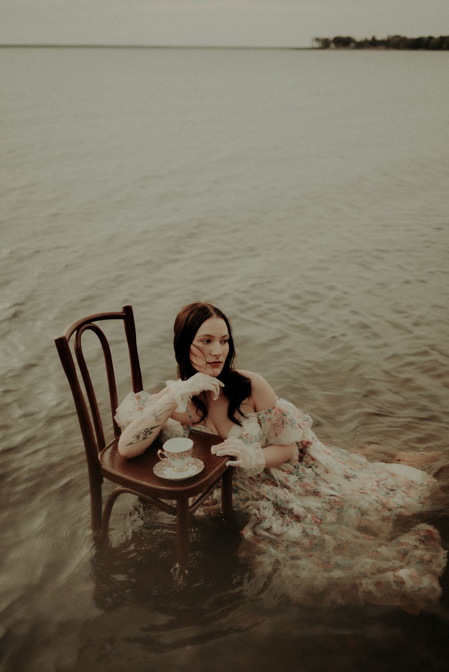An artistic water portrait with an antique chair and teacup creating a surreal atmosphere.