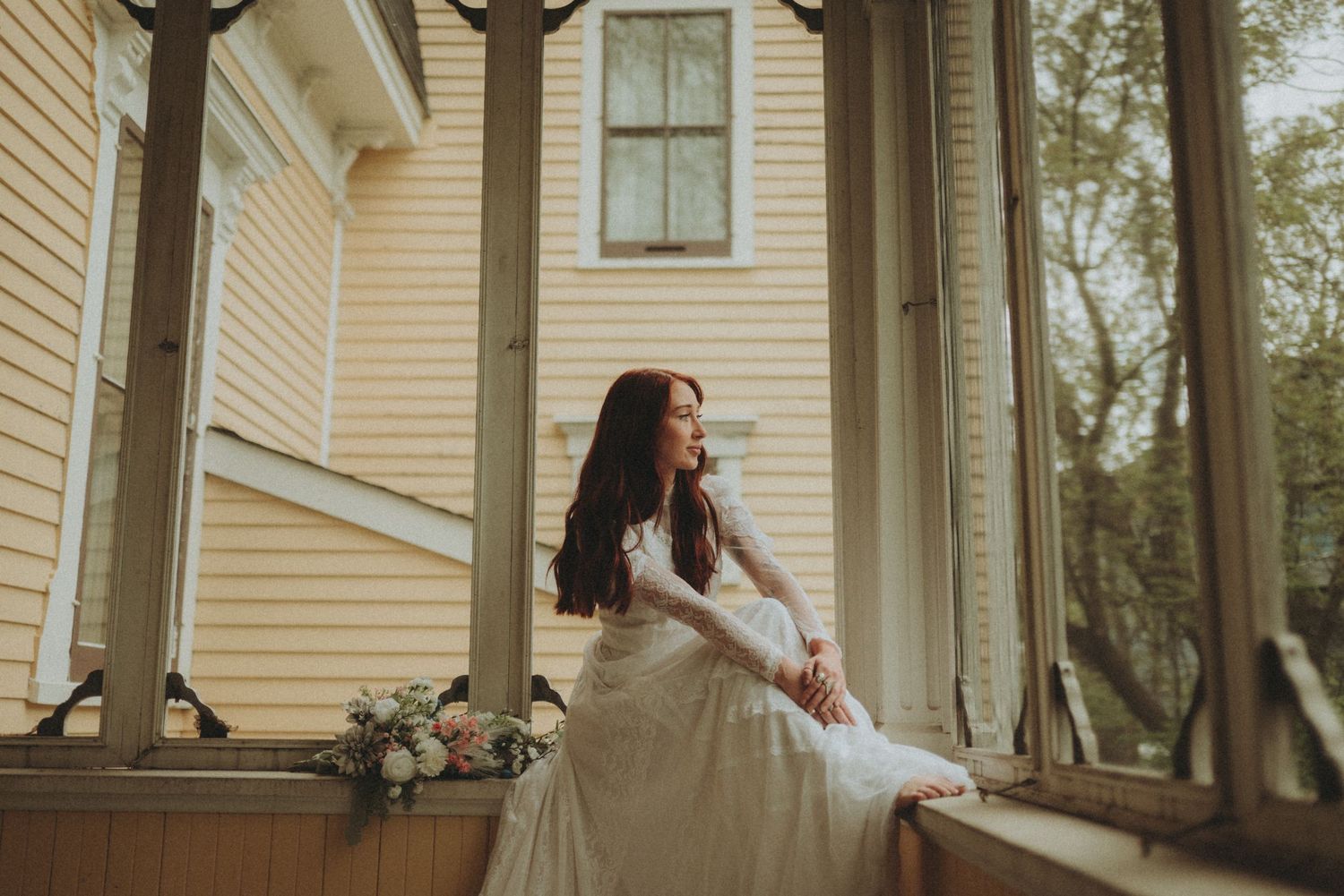 Dreamy bridal portraits captured on a sunlit veranda with cream-colored architectural details.