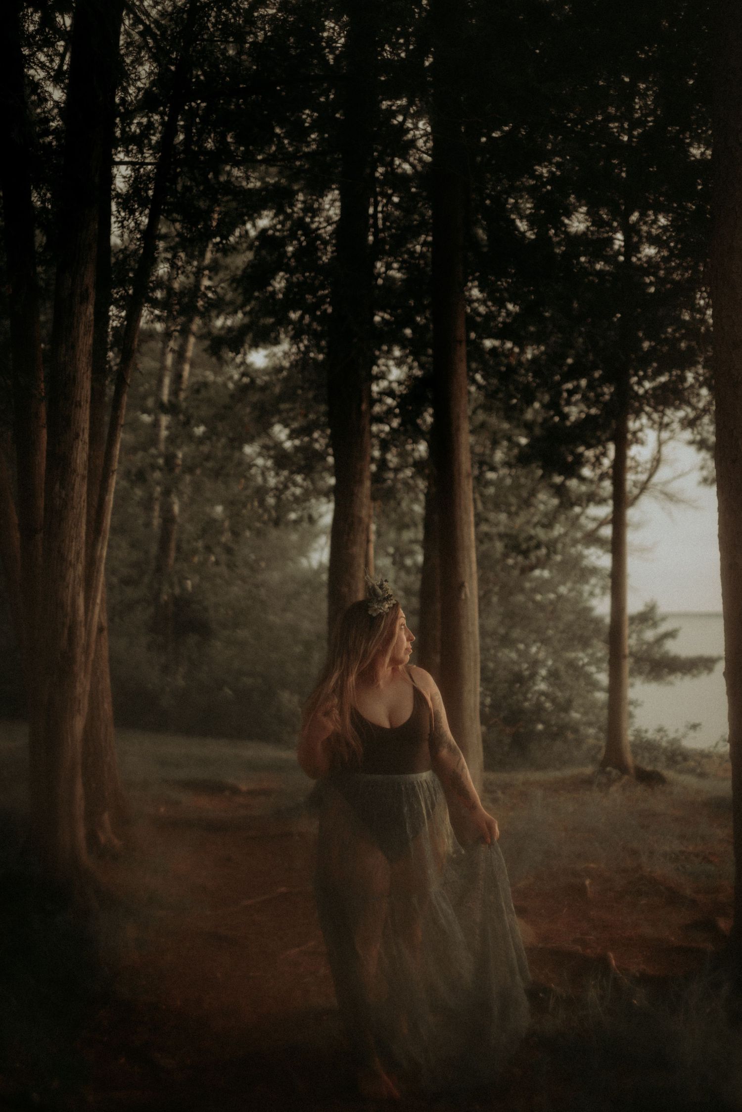 Moody forest portrait with warm lighting and ethereal movement in nature.