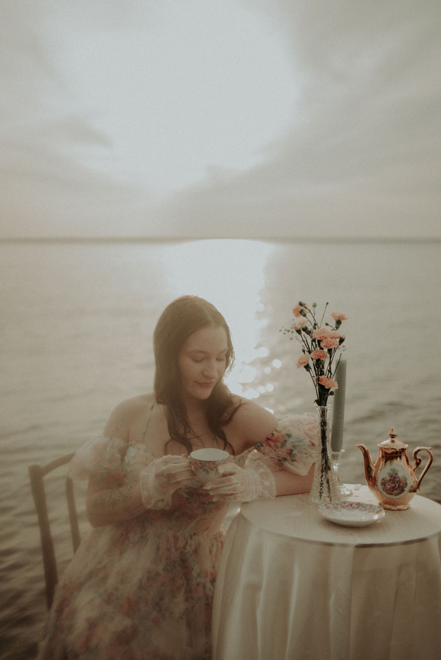 Whimsical tea party setup in water with delicate floral arrangements and vintage styling.